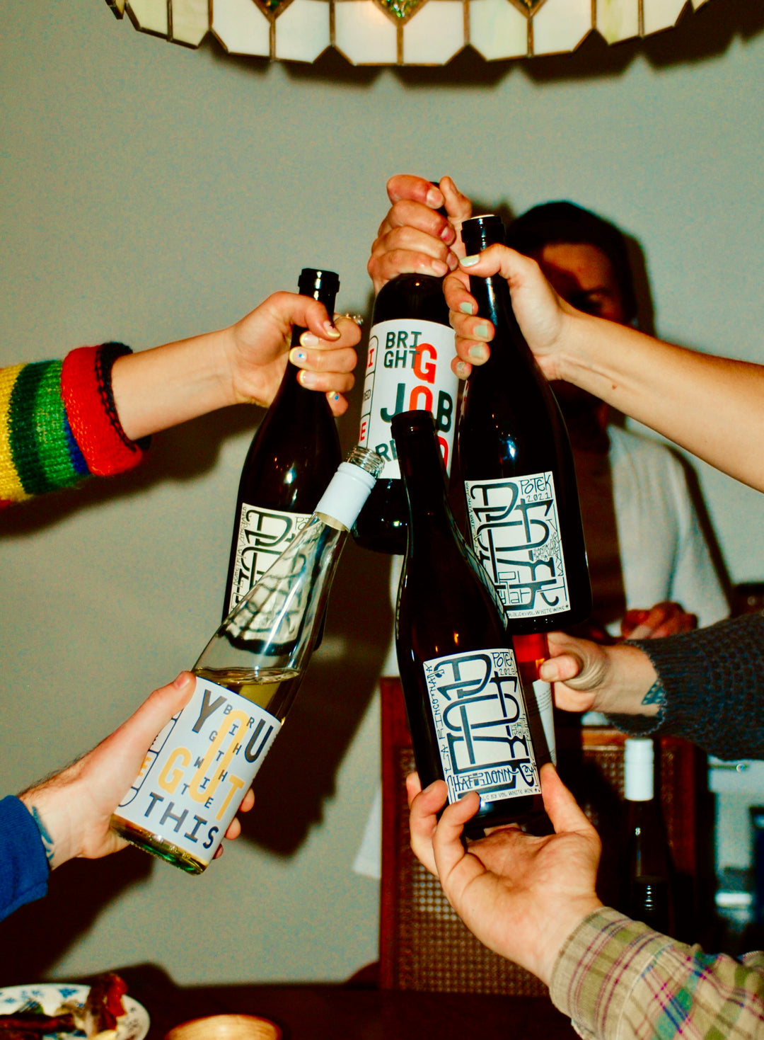 Friends clinking Municipal Winemakers bottles in a celebratory toast