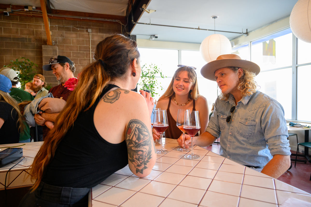Guests chatting over glasses of wine at the tiled bar in Muni Ventura.