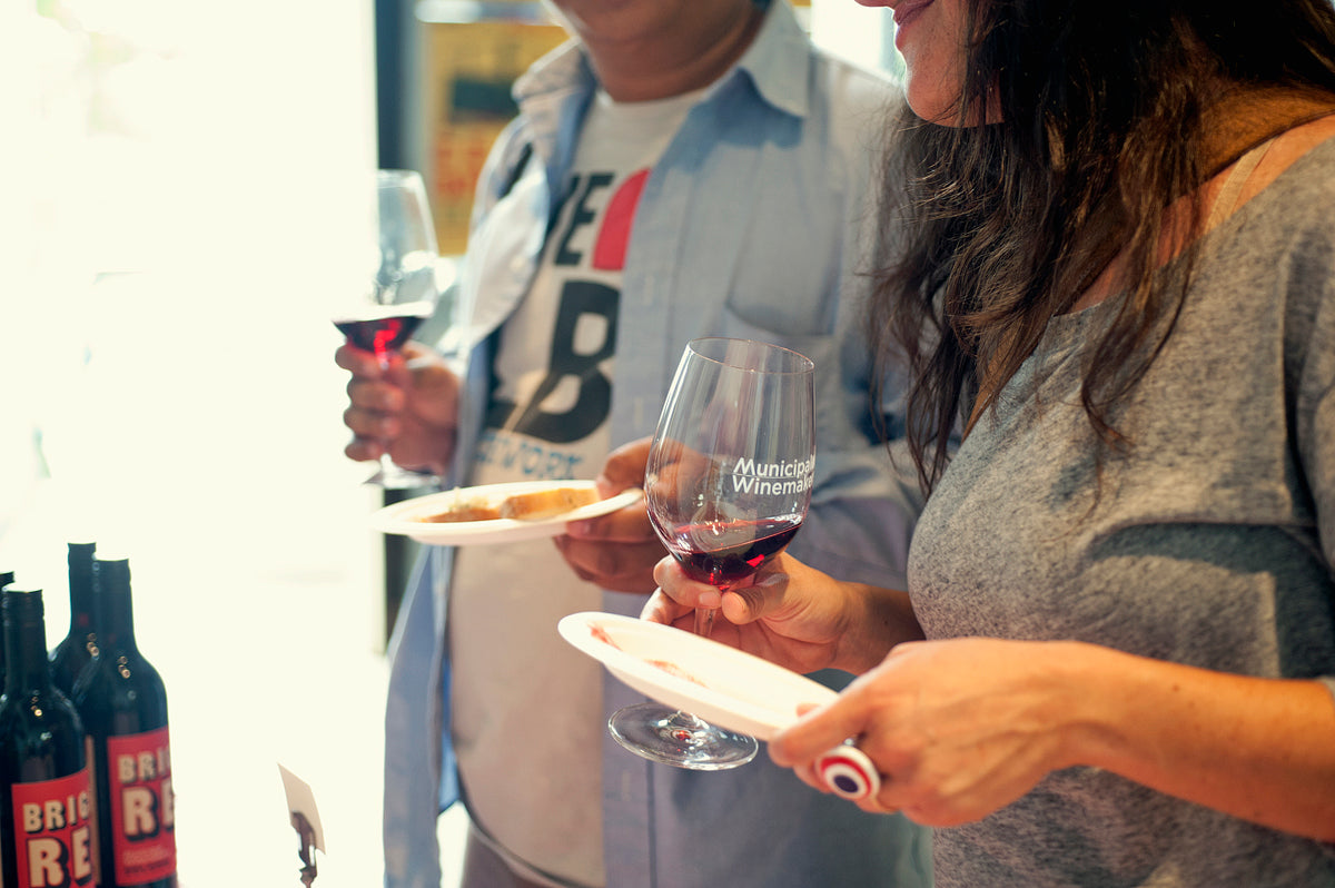 Guests holding Municipal wine glasses and tasting plates
